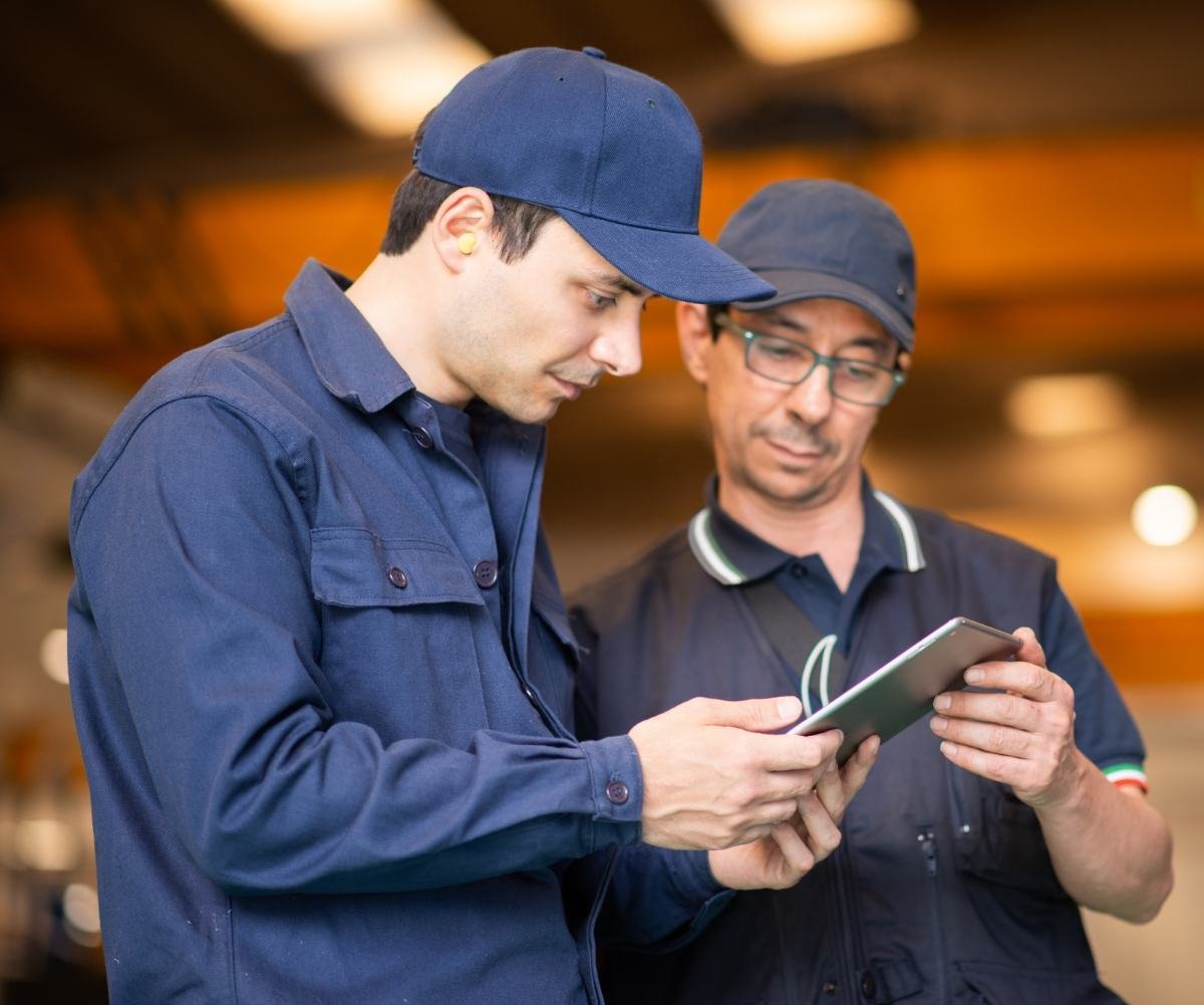 Two field service technicians reviewing a job on a tablet
